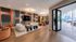 Modern and inviting lounge area with plush seating, vibrant wall designs, and large windows opening to a spacious patio.