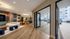 Chic modern lounge with colorful abstract wall art, elegant seating, and large glass doors opening to a bright, inviting patio area.