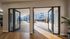 Chic apartment view showcasing glass doors opening to a sunlit courtyard with colorful plants and outdoor seating.