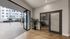 Bright and inviting apartment entrance with sleek sliding glass doors, modern lighting, and a glimpse of the cozy outdoor patio.