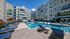 Modern apartment complex featuring a stunning outdoor pool area surrounded by sleek lounge chairs and vibrant building design.