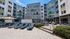 Modern apartment complex with vibrant exterior, featuring spacious outdoor lounge area and sunbeds by the pool, perfect for relaxation and social gatherings.