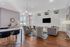 Luxurious open-concept living area with modern furnishings, sleek hardwood floors, and an elegant chandelier.