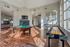 Spacious and bright game room with a pool table, shuffleboard, and cozy seating in a modern apartment complex.
