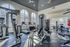 Modern gym with high ceilings, featuring state-of-the-art fitness equipment and large arched windows for abundant natural light.