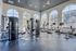 Bright and spacious fitness center with modern equipment, large arched windows, and scenic views.