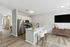 Modern apartment offering a sleek kitchen with stainless steel appliances, inviting breakfast bar with stools, and cozy living area. Perfect for stylish urban living.