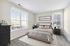 Elegant bedroom with large windows, plush carpeting, and stylish decor for a cozy atmosphere.