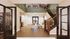 Inviting entryway with elegant staircase, modern decor, and welcoming seating area.