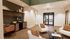 Chic apartment lounge with warm lighting, modern coffee bar, and plush seating area for relaxation.
