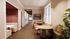 Inviting and elegant hallway with stylish seating areas and framed art, enhanced by warm lighting and large windows.