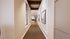 Inviting hallway with elegant decor, large windows, and modern lighting leading to a stylish office space.