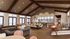 Elegant open-concept living space with vaulted ceilings, cozy seating, a large dining table, and a modern kitchen island.