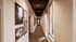 Elegant hallway with warm lighting, featuring large windows and artistic photo frames, creating a welcoming ambiance.