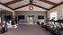 Elegant home gym with vaulted ceilings, featuring modern treadmills, weight racks, and stylish decor.