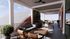 Chic rooftop patio with modern seating, lush green wall, and stylish ceiling fans offering panoramic views.