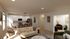 Bright open living area with a cozy beige sectional, modern kitchen with sleek appliances, and inviting reading nook.