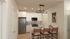 Modern kitchen design with elegant pendant lighting, sleek appliances, and a cozy breakfast bar with stylish seating.