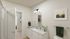 Elegant bathroom with modern fixtures, double vanity, stylish lighting, and tasteful art adorning the walls.
