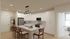 Chic modern kitchen with sleek white cabinets, elegant lighting, and spacious island with seating, perfect for entertaining.