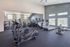 Modern fitness center with state-of-the-art exercise equipment, ample natural light, and a spacious layout.