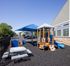 Inviting outdoor playground area with modern play structures and shaded seating, perfect for family-friendly living.