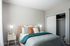 Cozy and inviting bedroom with elegant lighting, plush bedding, and spacious closet featuring modern sliding doors.