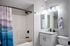 Modern bathroom with elegant granite countertop, sleek fixtures, and artistic shower curtain providing a stylish and serene atmosphere.