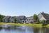 Charming residential community with stylish townhomes, lush landscaping, and serene pond views perfect for modern living.