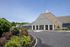 Inviting apartment complex entrance featuring elegant stone facade and lush landscaped gardens.