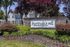 Charming luxury apartment community entrance with beautifully landscaped gardens and vibrant flowering plants.