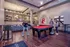 Inviting communal lounge with a vibrant red pool table, modern artwork, and cozy seating area, perfect for socializing and relaxation.
