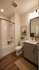 Elegant bathroom with a modern bathtub, sleek vanity, large mirror, and warm lighting, offering a serene spa-like atmosphere.