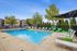 Inviting outdoor pool area with stylish lounge chairs and vibrant greenery, perfect for relaxation and leisure.