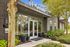 Inviting entrance of Trotters apartment complex with modern design, lush greenery, and vibrant flower arrangements.