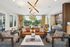 Luxurious and modern living room with a chic leather sofa, stylish lighting fixture, and a view of a serene outdoor patio.