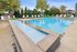 Inviting outdoor pool area with crystal-clear water, surrounded by chic lounge chairs and vibrant umbrellas, exuding a relaxing and luxurious ambiance.
