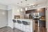 Modern kitchen with sleek granite countertops, stainless steel appliances, and stylish bar seating.
