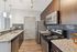 Elegant modern kitchen with granite countertops, stainless steel appliances, and chic dark wood cabinetry.