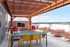 Chic rooftop terrace featuring vibrant seating under a wooden pergola, perfect for outdoor relaxation and entertainment.