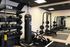 Modern fitness room equipped with TRX bands, kettlebells, free weights, and a punching bag, ideal for a complete workout experience.