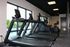 State-of-the-art gym with modern treadmills and exercise bikes, offering a scenic view of the pool and greenery through large windows.