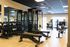 Modern fitness center featuring state-of-the-art gym equipment, including a rack of dumbbells, versatile workout benches, and sleek cardio machines, all set in a bright, spacious area.