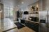 Modern kitchen with sleek cabinetry, a built-in coffee bar, and stainless steel appliances, offering a bright and inviting space with large windows and contemporary finishes.