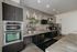 Modern kitchen with sleek stainless steel appliances, elegant dark cabinetry, and stylish open shelving, creating a sophisticated and functional space.