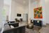 Contemporary living area with modern art, plush sofas, stylish armchairs and a unique honeycomb table creating a vibrant and welcoming atmosphere.