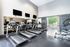 Modern gym facility equipped with multiple treadmills, wall-mounted TVs, and a bright, spacious interior with large windows.