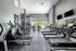 Modern, well-equipped fitness center with state-of-the-art treadmills, exercise bikes, and bright natural lighting.