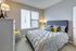 Bright and cozy bedroom with stylish decor, featuring a plush bed and elegant lighting, creating a warm and inviting atmosphere.