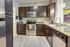 Modern kitchen with sleek dark cabinets, stainless steel appliances, and elegant countertops, creating a welcoming open space.
